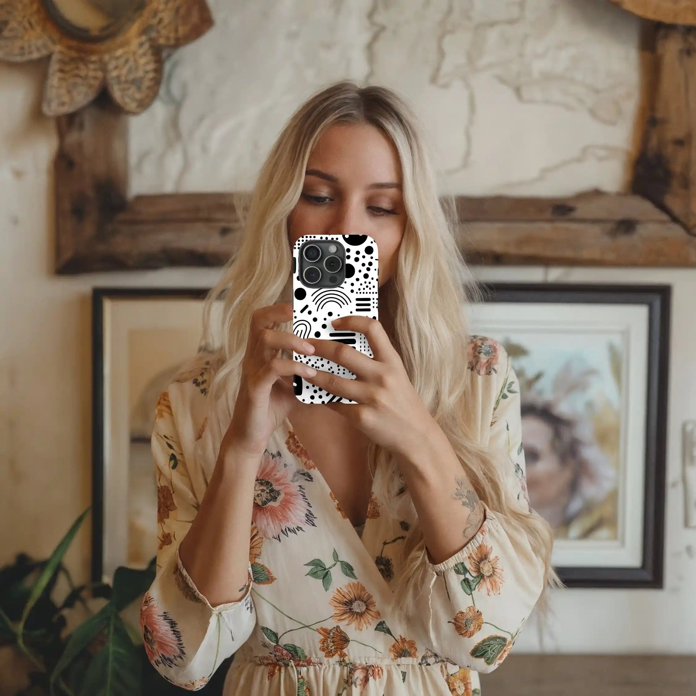 Styled image of model holding black and white abstract phone case
